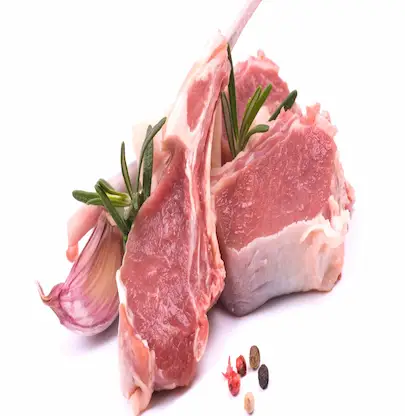Raw lamb chops with rosemary, garlic, and pepper on a white background
